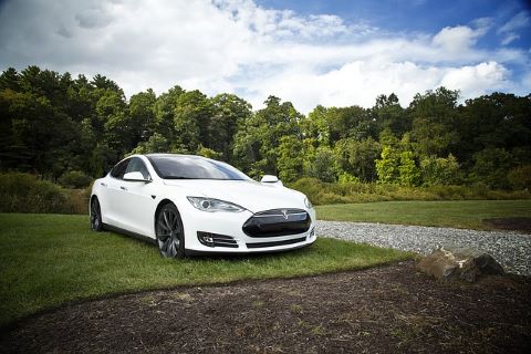 Parkender weißer Tesla, der mit Hilfe einer günstigen Elektroauto-Finanzierung erworben wurde