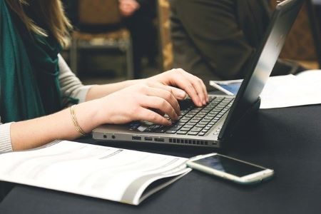 Angestellte im Öffentlichen Dienst am Laptop auf der Suche nach einem günstigen Kredit