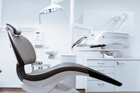 Schwarzer Stuhl im Behandlungszimmer einer modernen Zahnarztpraxis: Neue Zähne sind oft teuer und müssen über einen Zahnkredit finanziert werden