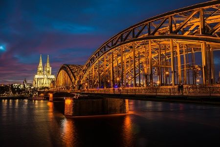 Nachtaufnahme des beleuchteten Kölner Dom und der Kölner Rhein-Brücke: Wenn Sie in Köln schnell Geld benötigen, könnten Sie einem Leihhaus Köln einen Besuch abstatten!