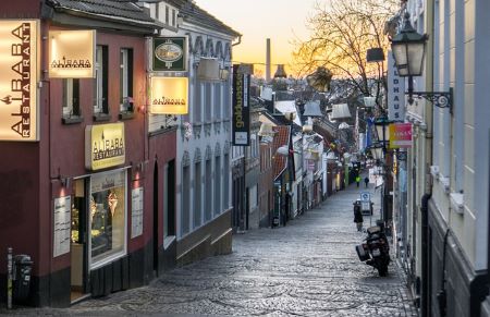 Straße mit Häusern und Restaurants in Mönchenglachbach: Solltest du einen Sofortkredit benötigen, hast du die Möglichkeit, einen solchen in einem Leihhaus Mönchengladbach zu erhalten!
