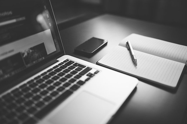 Laptop, Iphone, Notizblock und Stift auf einem Schreibtisch: Wenn Sie einen Kredit iHv 55000 Euro benötigen, dann können Sie hier einen Kreditvergleich machen und ein günstiges 55000 Euro Darlehen online beantragen!