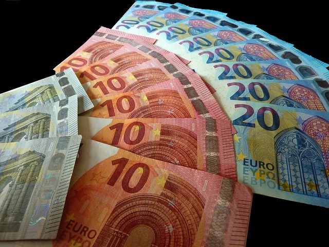 5-, 10- und 20-Euro Banknoten auf einer schwarzen Tischdecke: Sie benötigen Geld? Dann beantragen Sie doch einfach den günstigen Commerzbank Kleinkredit!