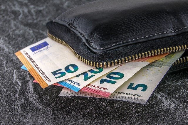 Schwarze Geldbörse, und Euro-Banknoten, die aus derselben "herauslugen": Wenn Sie Geld benötigen, können Sie beispielsweise einen günstigen Commerzbank Kredit aufnehmen!