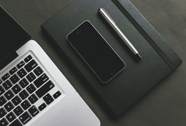 Notebook, iPhone, Stift und Notizbuch: Wenn Sie einen flexiblen Kredit benötigen, dann können Sie bequem von Zuhause aus den Degussa Bank Kredit online beantragen!