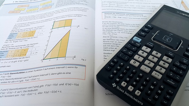 Taschenrechner auf einem aufgeschlagenen Mathematik-Buch: Wer die Zinsersparnis bei einer Umschuldung ausrechnen möchte, benötigt mathematisches Verständnis!