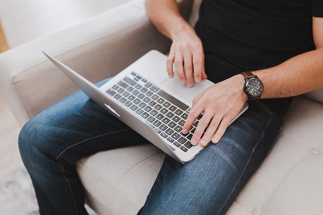 Mann mit Laptop auf dem Sofa sitzend: Wenn Sie einen günstigen Ratenkredit zur freien Verwendung benötigen, dann können Sie jetzt den bonitätsunabhängigen PSD Bank Privatkredit ab nur 3,68% eff. p.a. online beantragen!