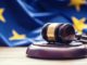 Richterhammer und EU-Flagge: Die PSD2 Richtlinie der EU regelt Zahlungsdienste im europäischen Raum.