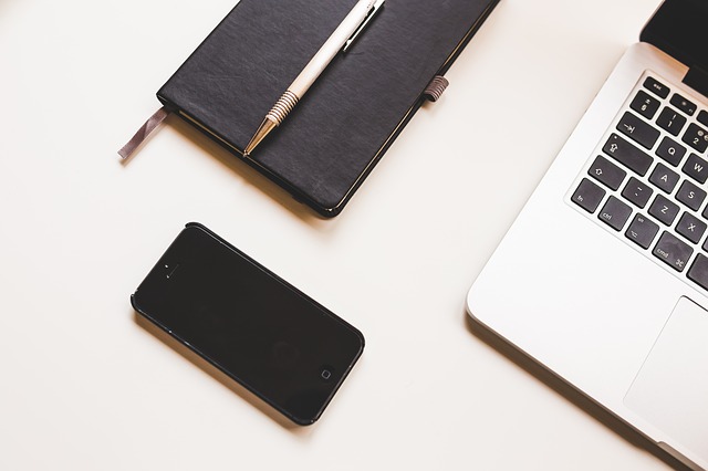 Smartphone, Notizbuch und Laptop auf einem weißen Tisch: Wenn Sie gerade auf der Suche nach einem günstigen Sofortkredit sind, dann können Sie noch heute den Qlick Kredit ab nur 1,48% eff. p.a. online beantragen!