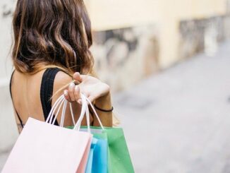 Glückliche Frau mit Einkaufstüten, die mit BNPL-Bezahlmethoden (Buy now, pay later) Waren eingekauft hat