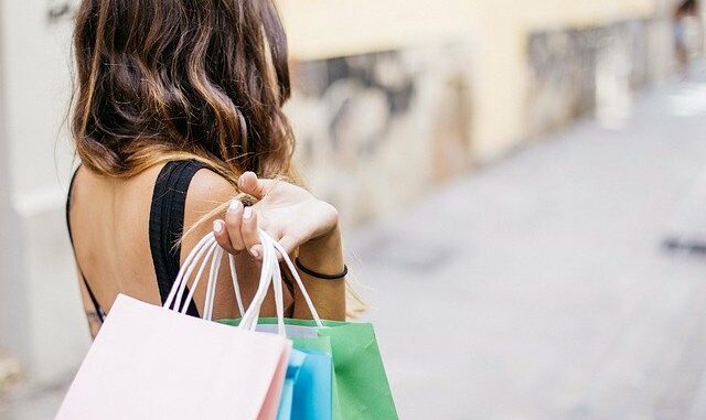 Glückliche Frau mit Einkaufstüten, die mit BNPL-Bezahlmethoden (Buy now, pay later) Waren eingekauft hat